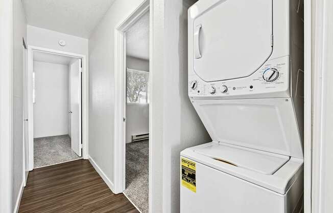 A white dryer is in a small room with a door open.