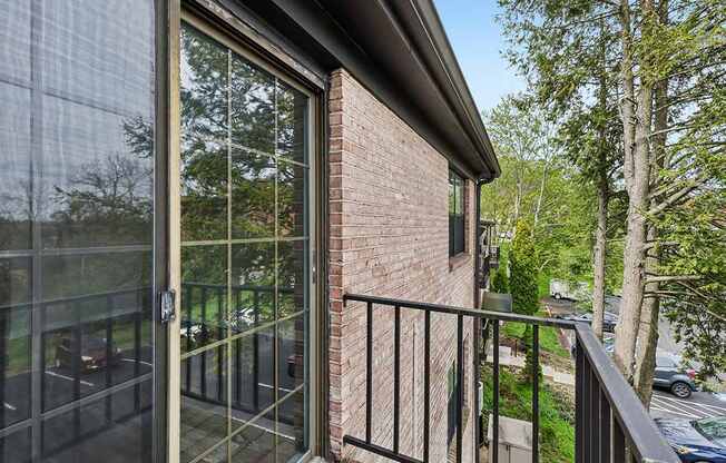 A balcony with a glass door and a black railing.