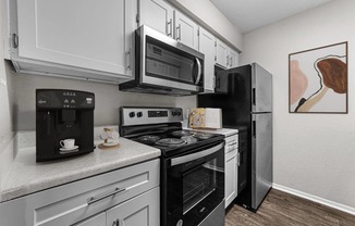 a kitchen with black appliances and white cabinets