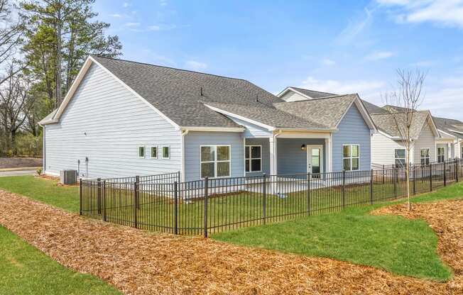 a white house with a black fence in front of it