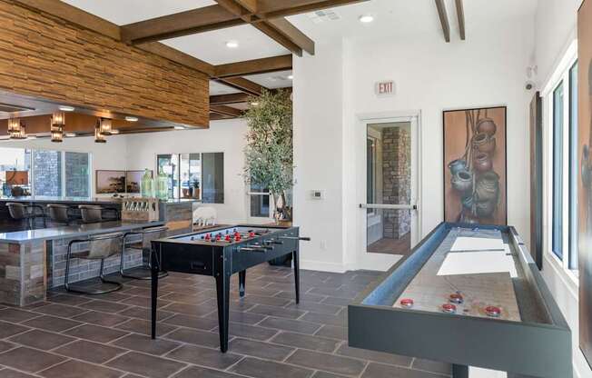 A pool table with a black cloth and red balls is in the center of a room with a wooden ceiling and a door marked "EXIT".