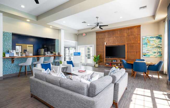A living room with a grey couch and a wooden wall.