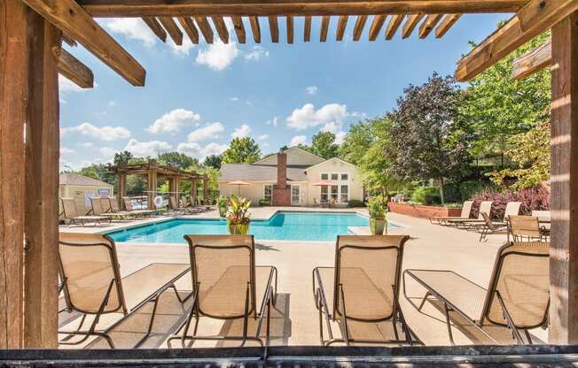 a swimming pool with chairs around it and a house in the background at Highland Ridge Apartments, Overland Park , KS 66210