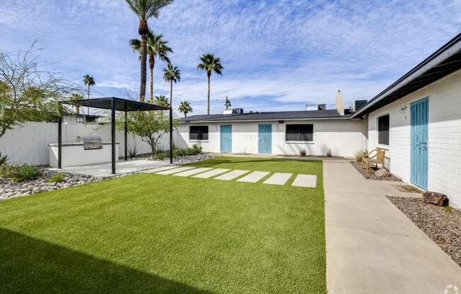 a white house with a yard and a blue door