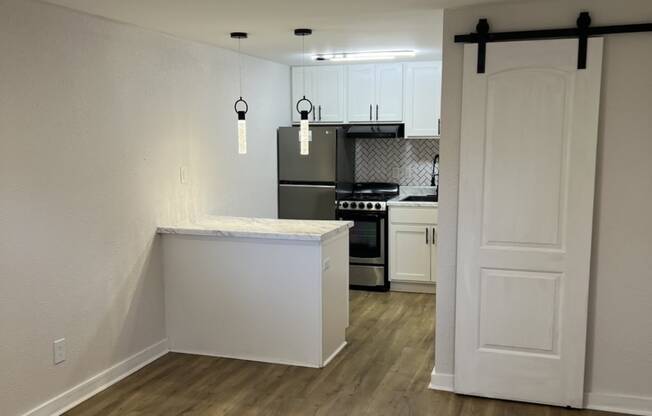 The Retreat at Indian Lake - studio kitchen with an island and a stove and a refrigerator