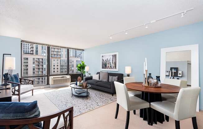 a living and dining room area with blue walls and a large window