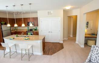 A kitchen with a white island and bar stools.