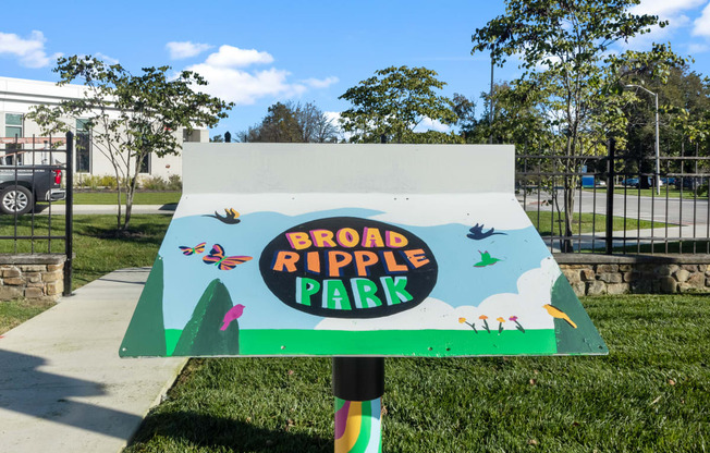 a sign that says broad ripple park in front of a sidewalk