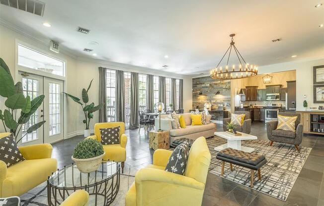 a living room with yellow couches and chairs and a kitchen