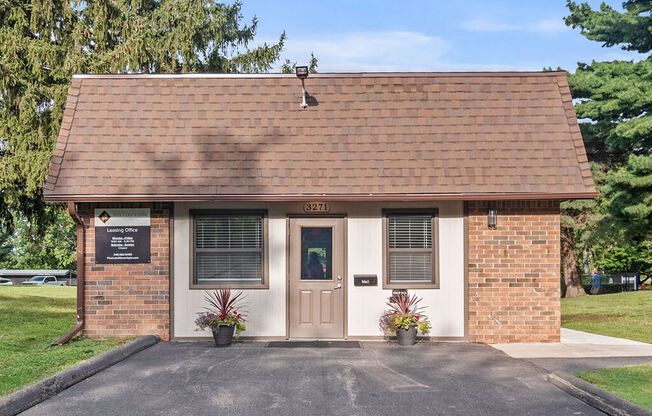 the front of a small brick building with a door