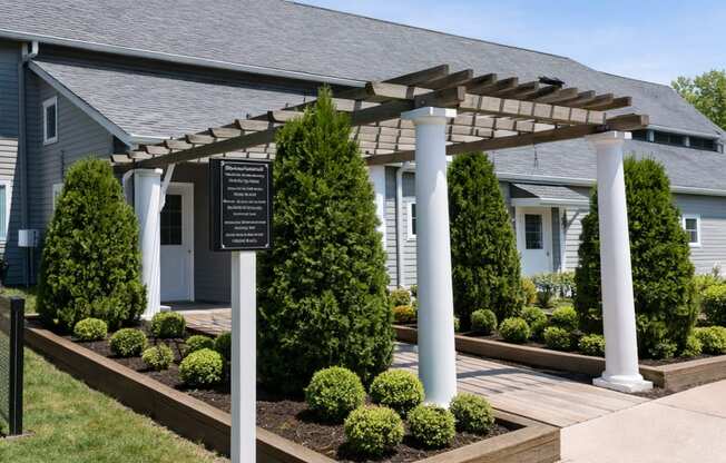 A house with a white porch and a pergola over it.