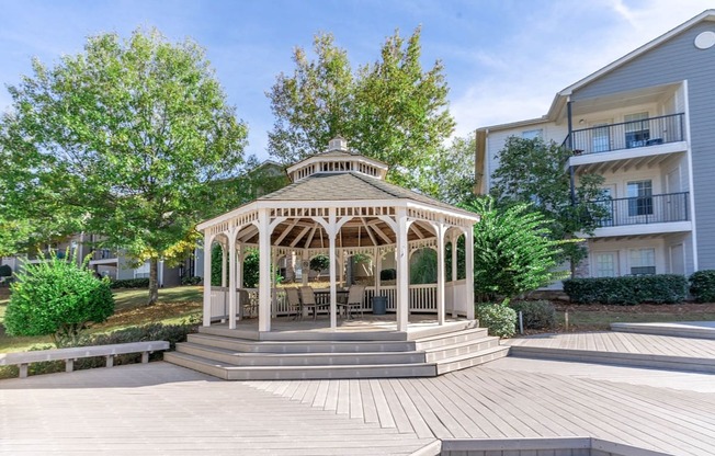 A gazebo is surrounded by a wooden deck and steps.