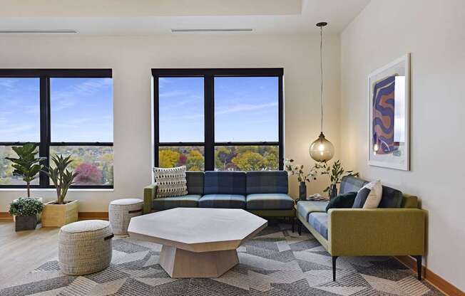 A living room with a couch, a table, and a large window.