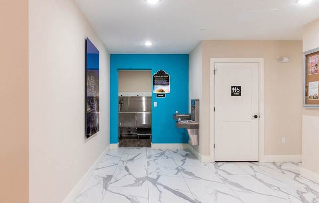 a hallway with a blue and white marble floor and a refrigerator