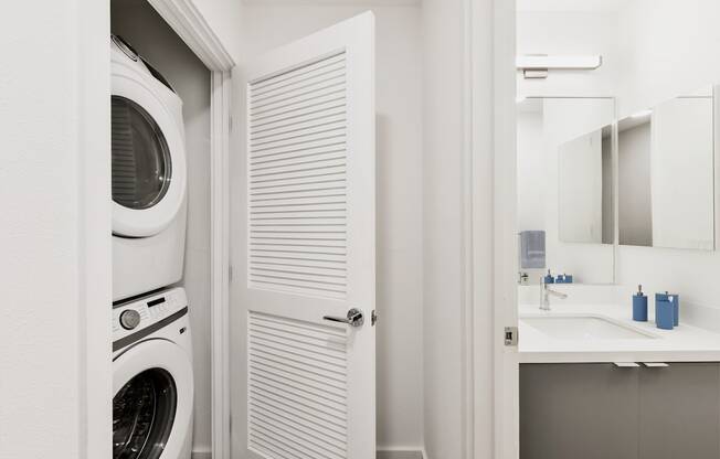 A white washing machine is in a small laundry room.