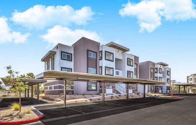 Modern apartment complex with stylish architecture, featuring covered parking and beautifully landscaped surroundings under a clear blue sky at Summit on Boulder Apartments.