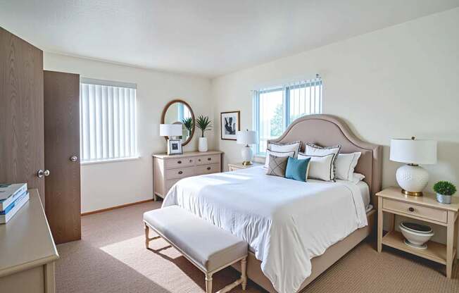 A bedroom with a large bed, a nightstand, and a dresser.