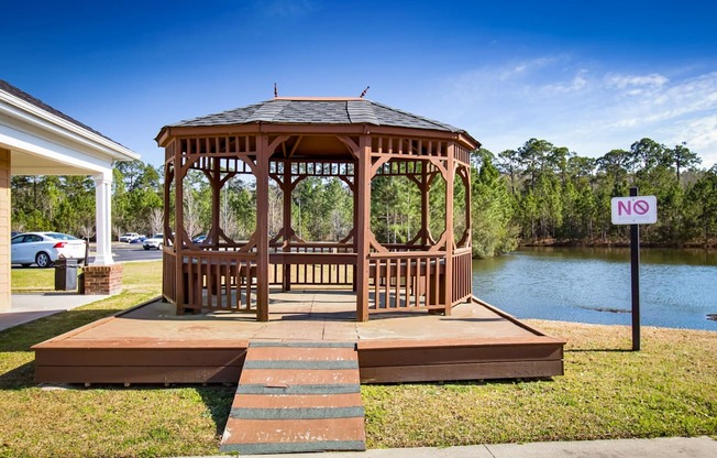 a gazebo with a no trespassing sign next to a lake