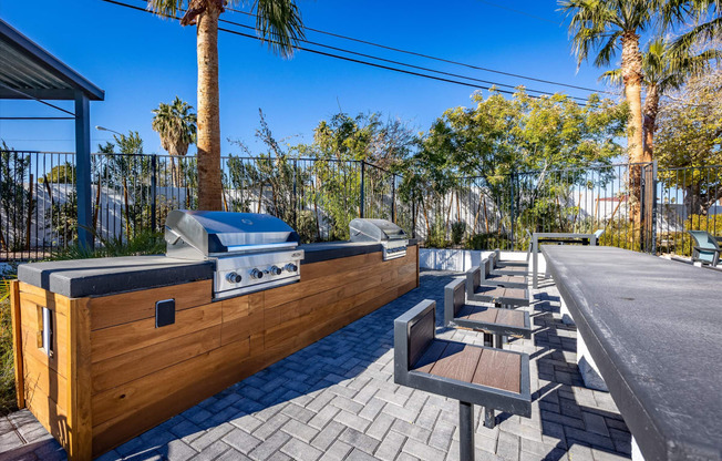 a patio with a grill and tables and chairs