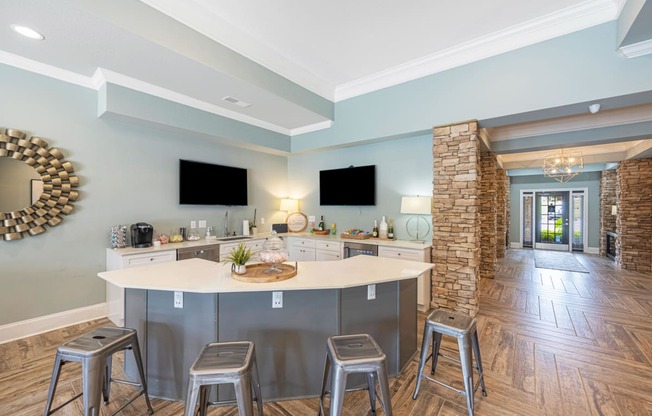 a kitchen with a large island with three stools