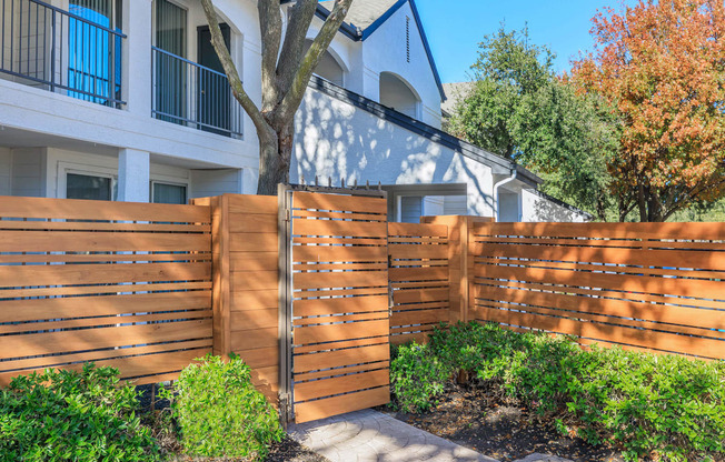 a wooden fence in front of a white building