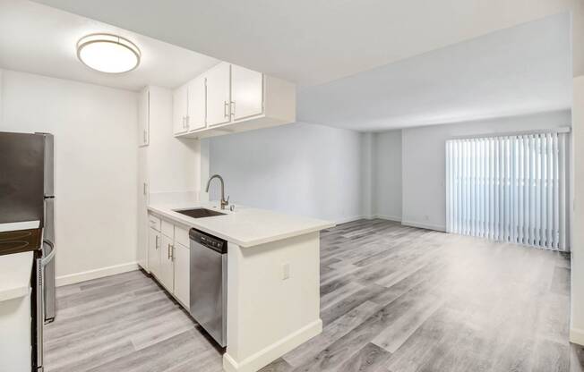 an empty kitchen and living room with a large window