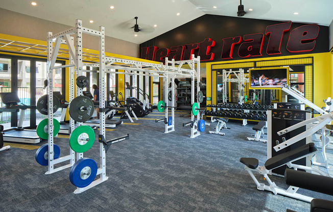 a gym with weights and cardio machines and a neon sign