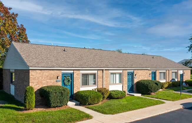 a brick building with blue doors and shutters