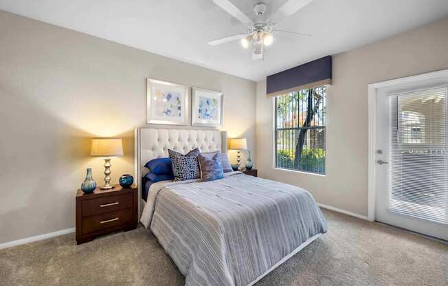 A bedroom with a bed, nightstand, and a ceiling fan.