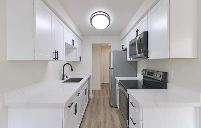 Open kitchen with stainless appliances and wood-style floors in Redmond, WA apartment