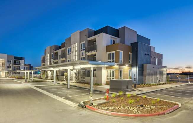 a building with a parking lot in front of it at night