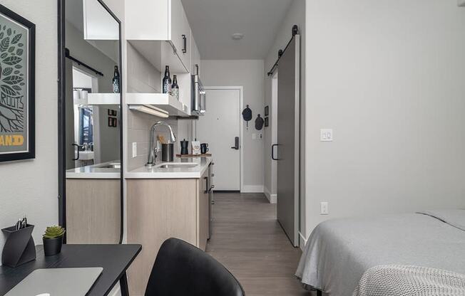 a bedroom with a bed and a desk in a room
