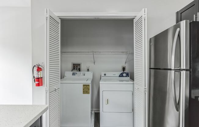 a laundry room with two washes and a refrigerator