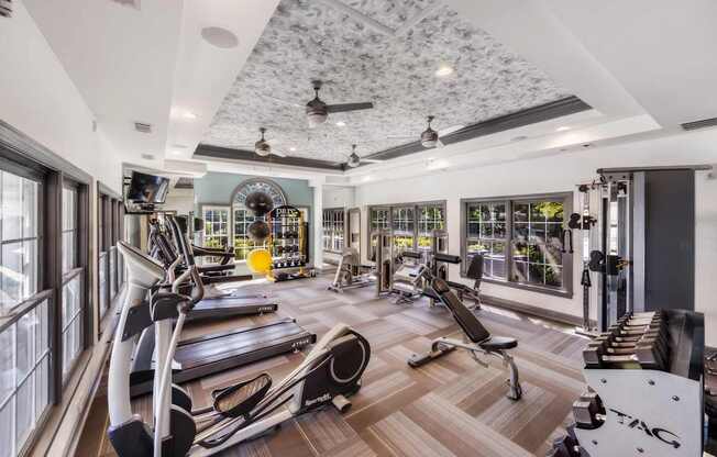A gym with treadmills, weights, and exercise equipment.