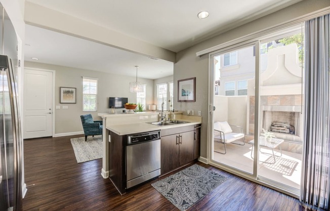a kitchen with dishwasher and sink with sliding glass door