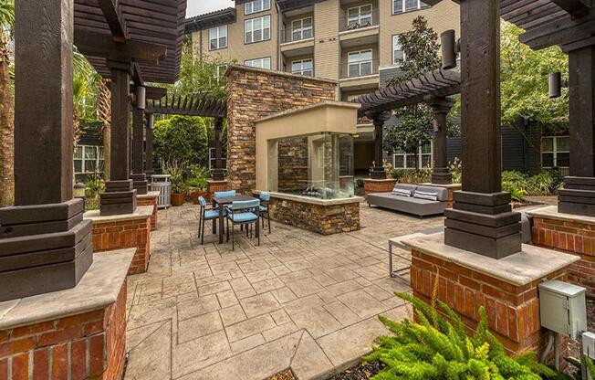 a patio with a table and chairs in front of a building