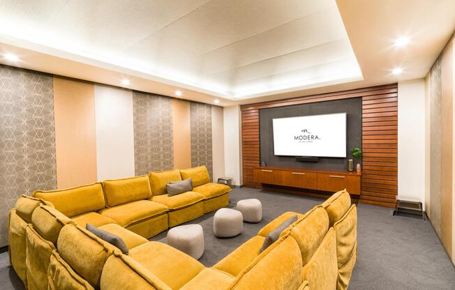 A private theater room with plush seating, layered lighting, and a large display, offering a comfortable space for movie nights or small gatherings.