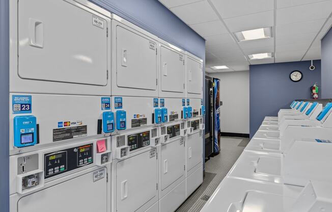 a row of gray lockers in a room with a clock on the wall