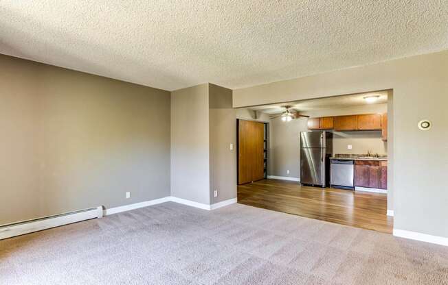 an empty living room with a kitchen in the background  at ReNew at Neill Lake, Eden Prairie, Minnesota