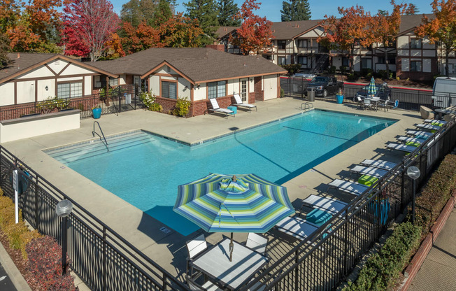 a swimming pool with umbrellas and lounge chairs around it at Rocklin Manor  Apartments, Rocklin  ,California, 95677