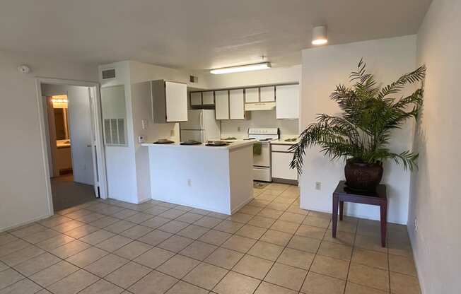Kitchen view with ceramic tile flooring, breakfast bar, and white appliances.
