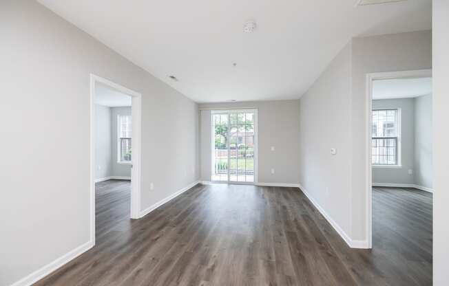 an empty living room with white walls and wood floors