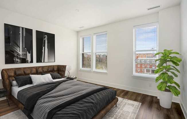 A bedroom with a large bed and a plant.at The Vale at the Parks, District of Columbia