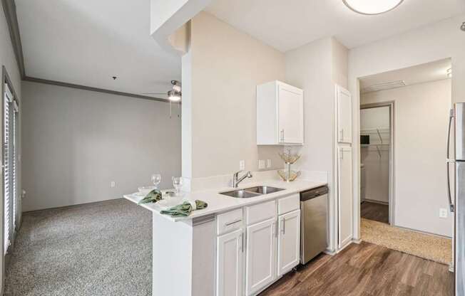 A kitchen with white cabinets and a sink.