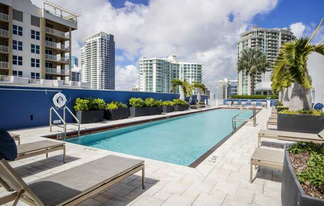 a swimming pool on the roof of a building with tall buildings