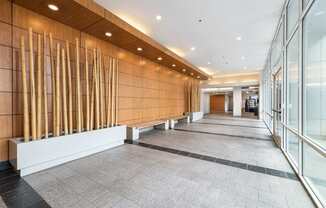 A long hallway with a row of wooden slats on the wall.
