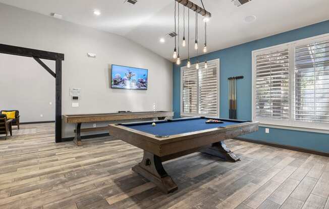 a games room with a pool table and a tv