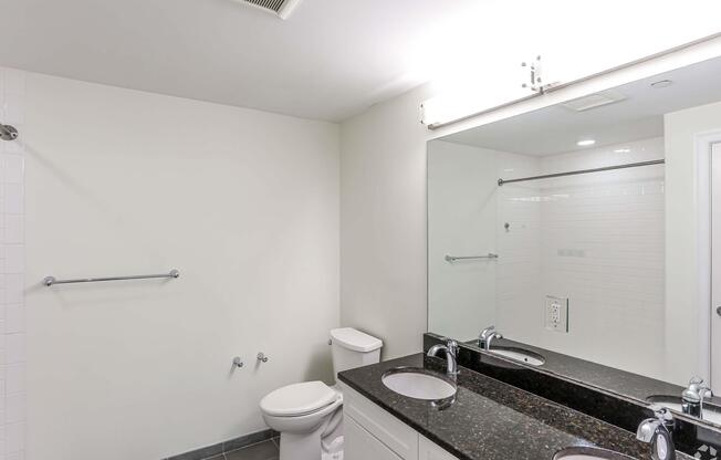 A white bathroom with a toilet, sink, and shower at 7 Cameron Apartments, Massachusetts