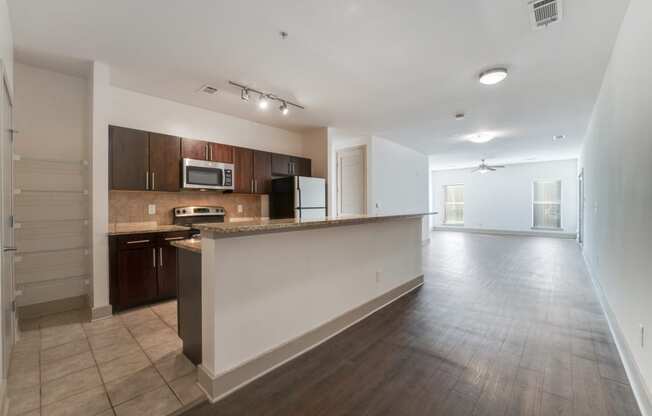 an empty kitchen and living room with a large counter top and