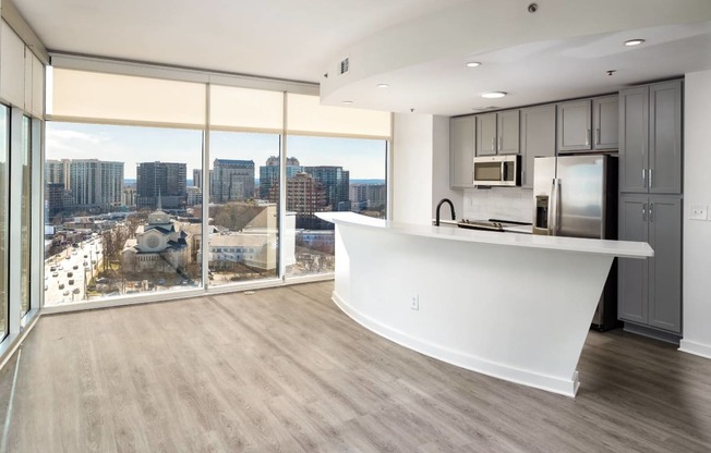 an open kitchen and living room with a view of the city